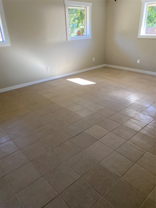 tiled spare room featuring a healthy amount of sunlight