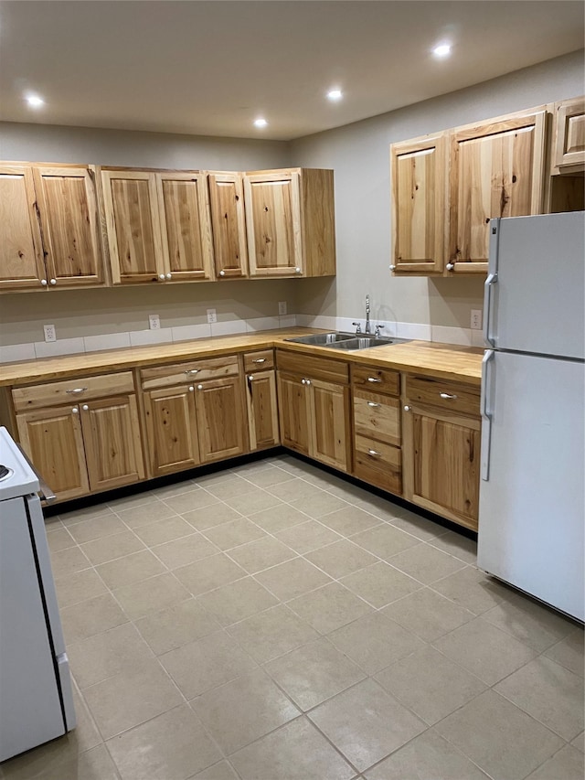 kitchen with white appliances, light tile patterned floors, and sink