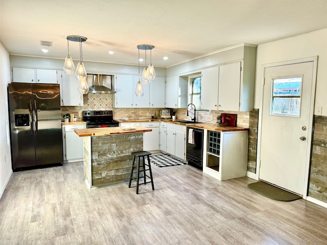 kitchen with stainless steel appliances, white cabinetry, and wooden counters