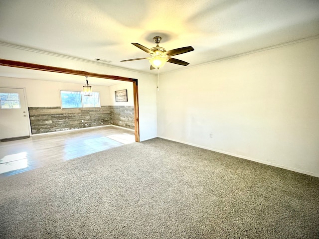 interior space with ornamental molding, a textured ceiling, ceiling fan, and carpet floors