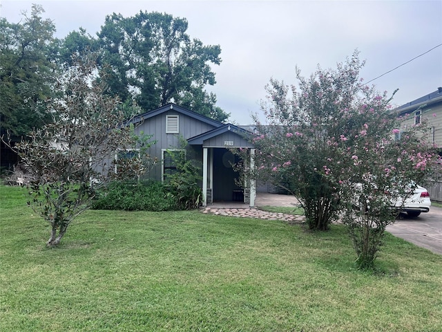 view of property hidden behind natural elements featuring a front lawn