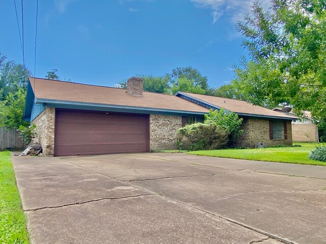 single story home featuring a front yard and a garage