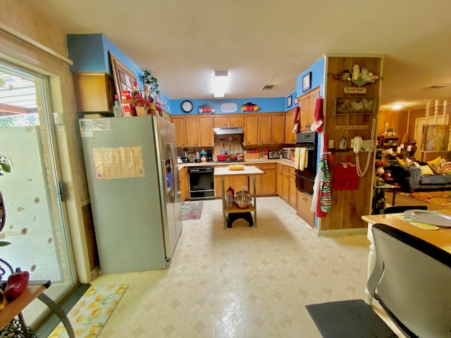 kitchen with stainless steel fridge with ice dispenser, oven, and a textured ceiling