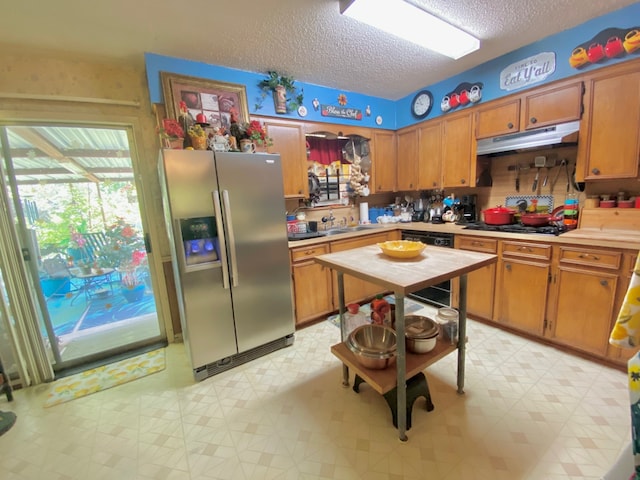 kitchen featuring a textured ceiling, black gas stovetop, sink, and stainless steel refrigerator with ice dispenser