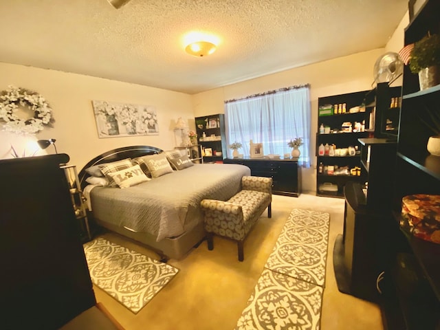 bedroom featuring light carpet and a textured ceiling