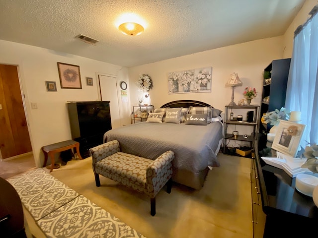 carpeted bedroom featuring a textured ceiling