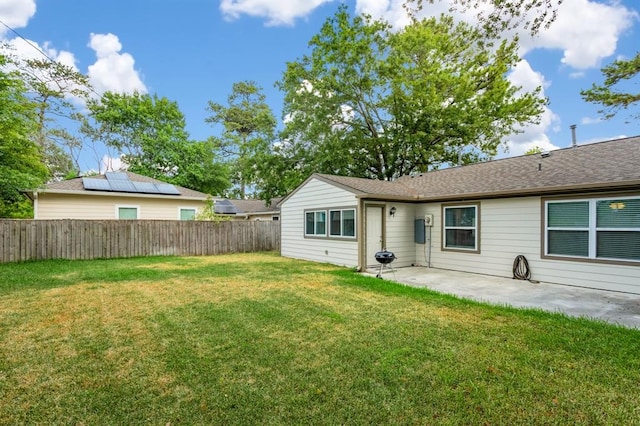 rear view of property featuring a lawn and a patio