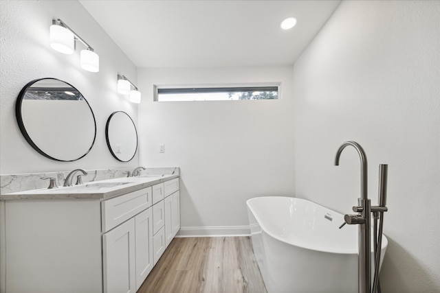 bathroom with hardwood / wood-style flooring, a bathing tub, and vanity