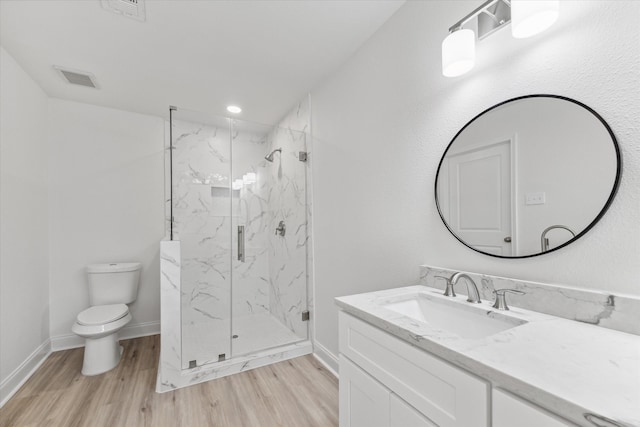 bathroom featuring toilet, a shower with door, hardwood / wood-style flooring, and vanity