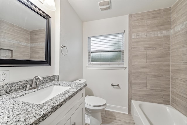 full bathroom featuring tiled shower / bath, vanity, and toilet