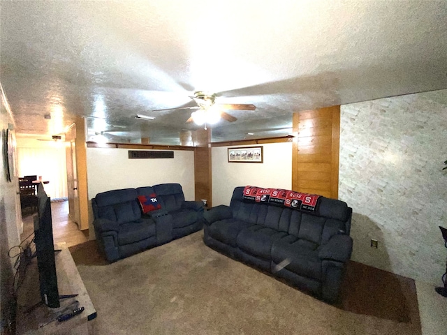 carpeted living room featuring a textured ceiling and ceiling fan