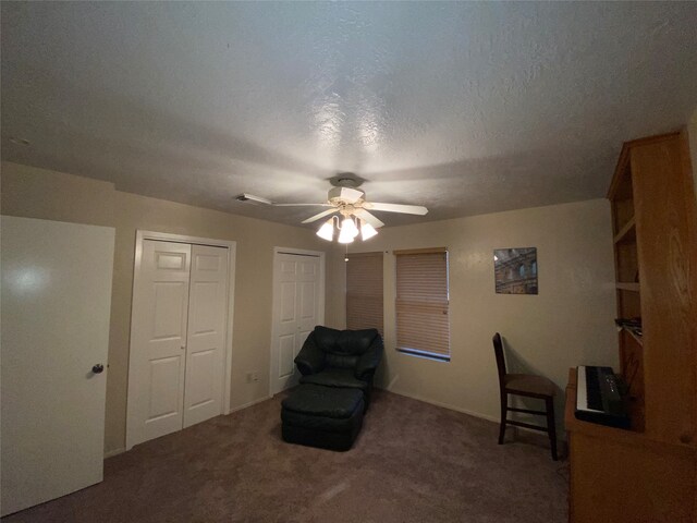 unfurnished room with a textured ceiling, ceiling fan, and carpet floors