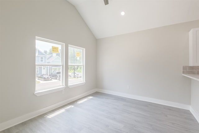 empty room with lofted ceiling and light wood-type flooring