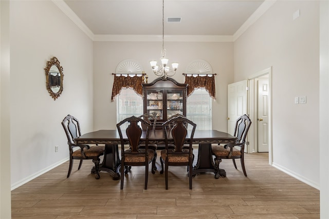 dining space featuring hardwood / wood-style floors, an inviting chandelier, and ornamental molding