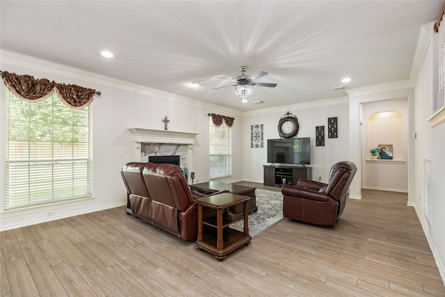 living room with a premium fireplace, ceiling fan, ornamental molding, and light hardwood / wood-style floors