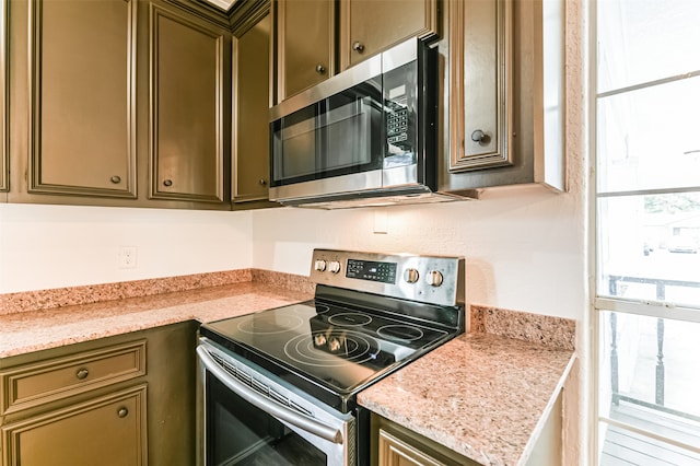 kitchen with appliances with stainless steel finishes and light stone counters