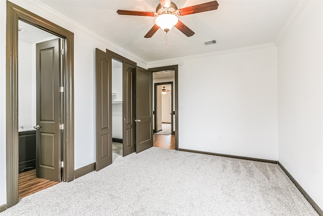 bedroom with crown molding, a textured ceiling, ceiling fan, and light colored carpet