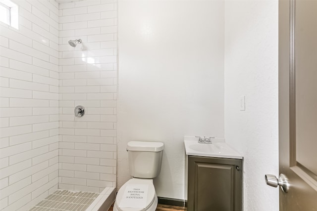 bathroom featuring vanity, toilet, and tiled shower