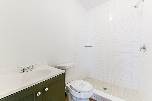 bathroom featuring vanity, toilet, and tiled shower