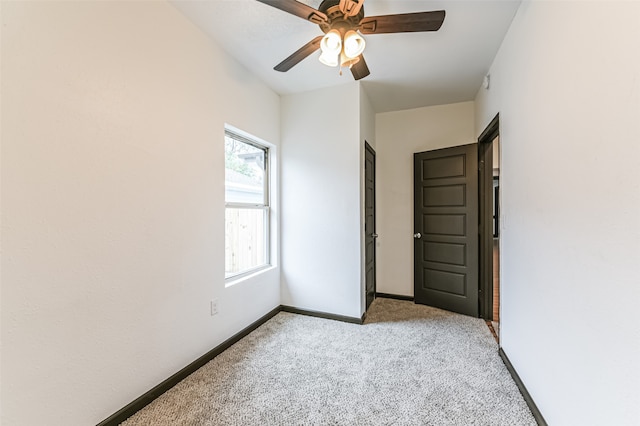 unfurnished room with light colored carpet and ceiling fan