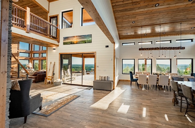 interior space with beam ceiling, high vaulted ceiling, and hardwood / wood-style flooring