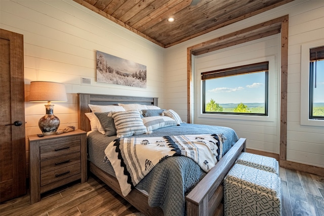 bedroom with hardwood / wood-style floors, wood ceiling, and wooden walls