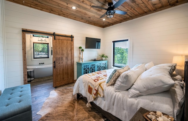 bedroom with dark hardwood / wood-style flooring, ensuite bathroom, wood ceiling, a barn door, and ceiling fan