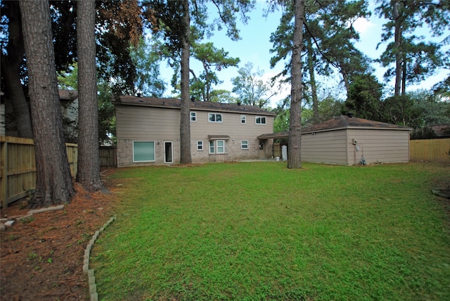 rear view of house with a lawn and an outdoor structure