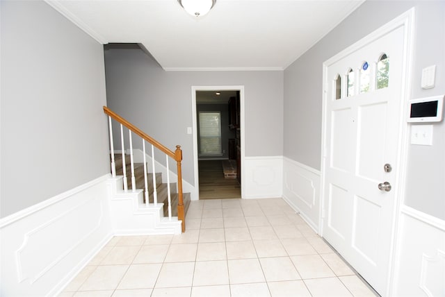 entrance foyer featuring crown molding and light tile patterned floors