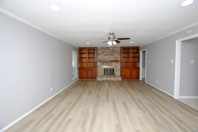 unfurnished living room with built in features, ceiling fan, light hardwood / wood-style floors, and a brick fireplace