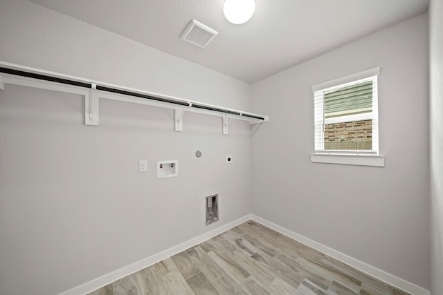 washroom featuring hookup for a gas dryer, hookup for a washing machine, light hardwood / wood-style floors, and hookup for an electric dryer