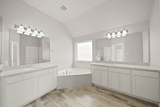 bathroom with shower with separate bathtub, hardwood / wood-style flooring, lofted ceiling, and vanity