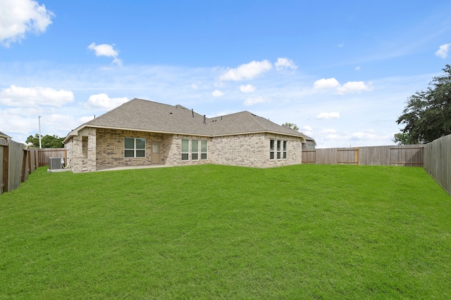 rear view of house featuring a lawn and central AC