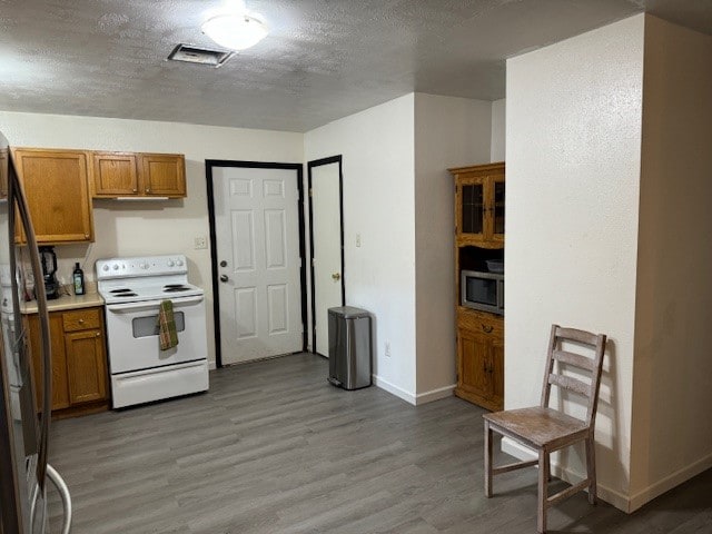 kitchen with stainless steel appliances, dark hardwood / wood-style flooring, and a textured ceiling