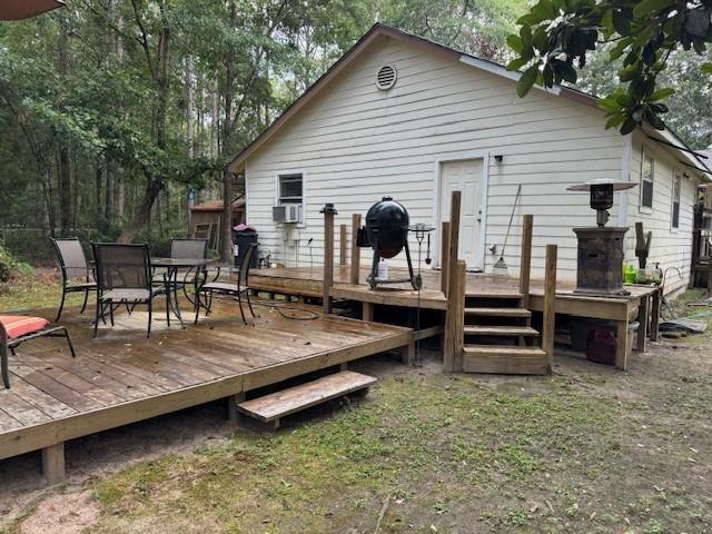 rear view of property featuring cooling unit and a wooden deck