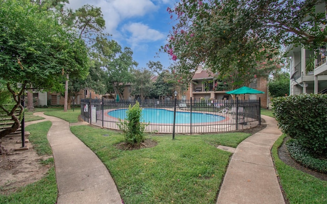 view of swimming pool with a yard