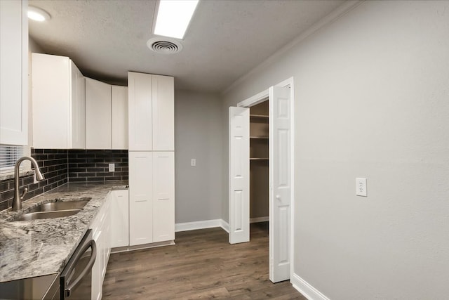 kitchen featuring white cabinets, light stone counters, dark hardwood / wood-style flooring, sink, and stainless steel dishwasher