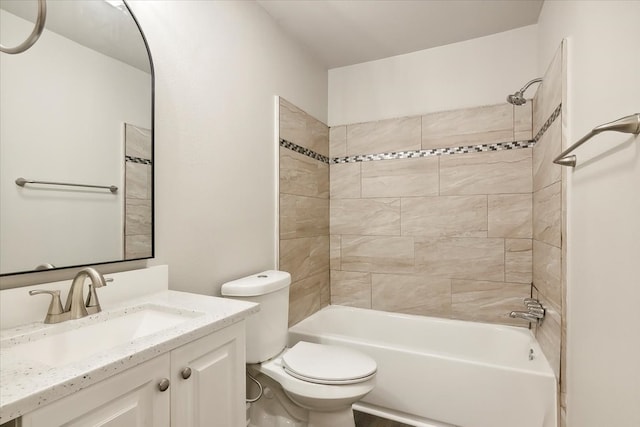 full bathroom featuring vanity, tiled shower / bath, and toilet