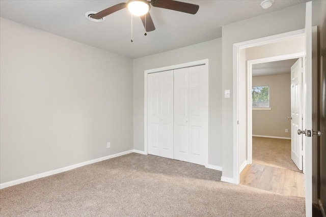 unfurnished bedroom featuring a closet, ceiling fan, and light carpet