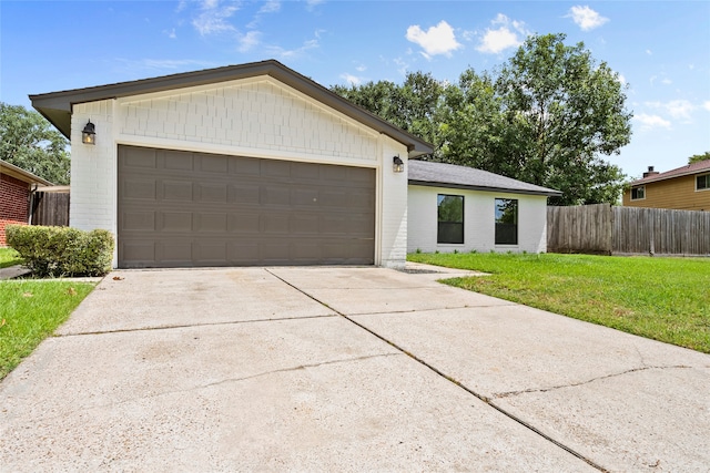 single story home featuring a garage and a front lawn