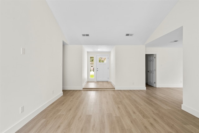 empty room featuring lofted ceiling and light hardwood / wood-style floors