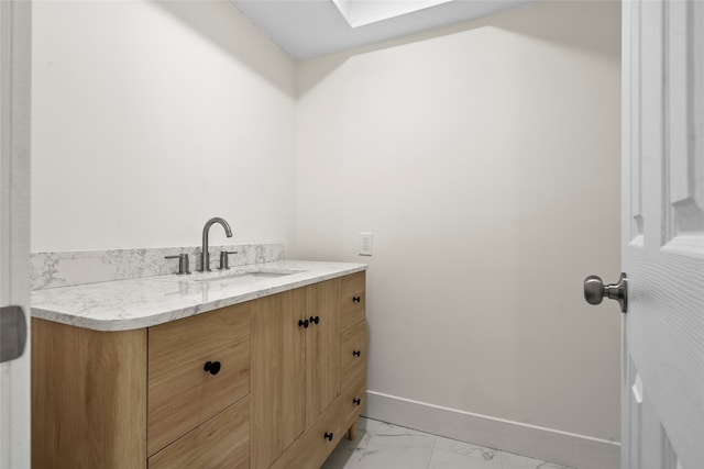 bathroom featuring a skylight and vanity