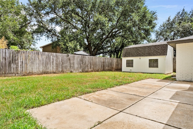 view of yard featuring a storage unit and a patio