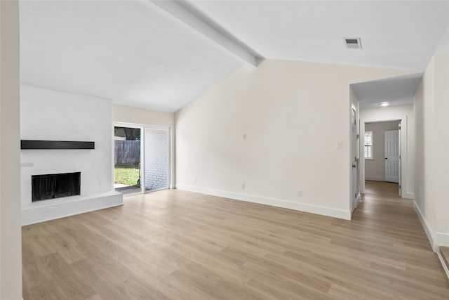 unfurnished living room featuring a large fireplace, light hardwood / wood-style floors, and vaulted ceiling with beams