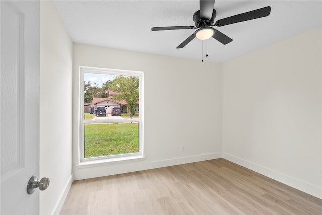 spare room featuring light hardwood / wood-style flooring, ceiling fan, and a healthy amount of sunlight