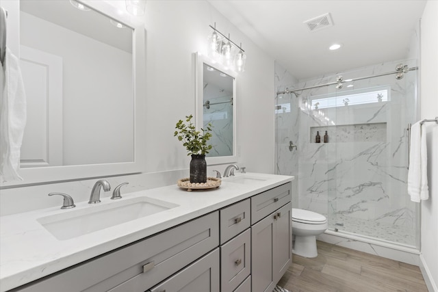 bathroom featuring hardwood / wood-style floors, vanity, toilet, and an enclosed shower