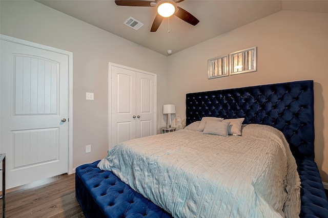 bedroom featuring lofted ceiling, hardwood / wood-style flooring, ceiling fan, and a closet