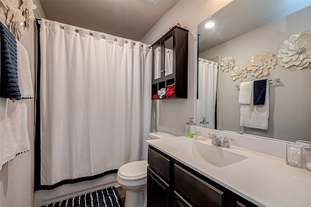 bathroom featuring vanity, toilet, and curtained shower