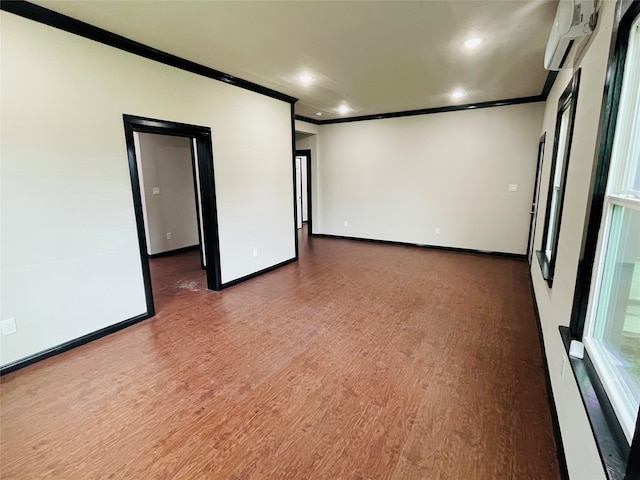 empty room with dark hardwood / wood-style floors, crown molding, and a wall unit AC