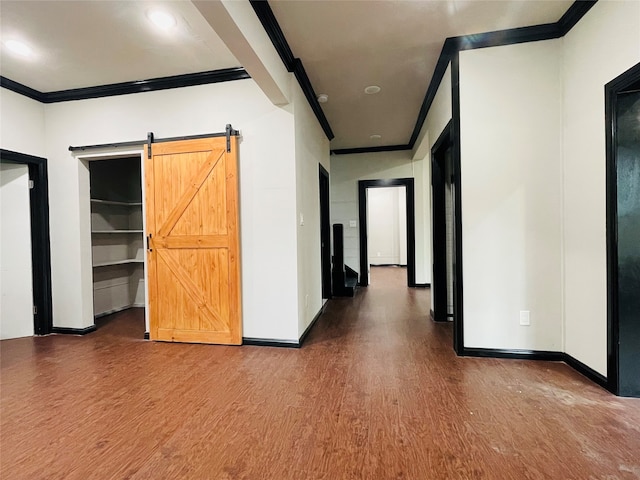 hall featuring wood-type flooring, a barn door, and crown molding